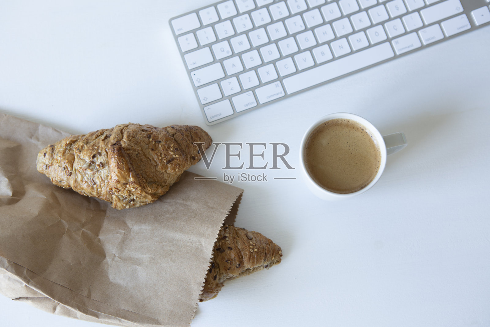 早上的背景。咖啡配羊角面包和电脑照片摄影图片