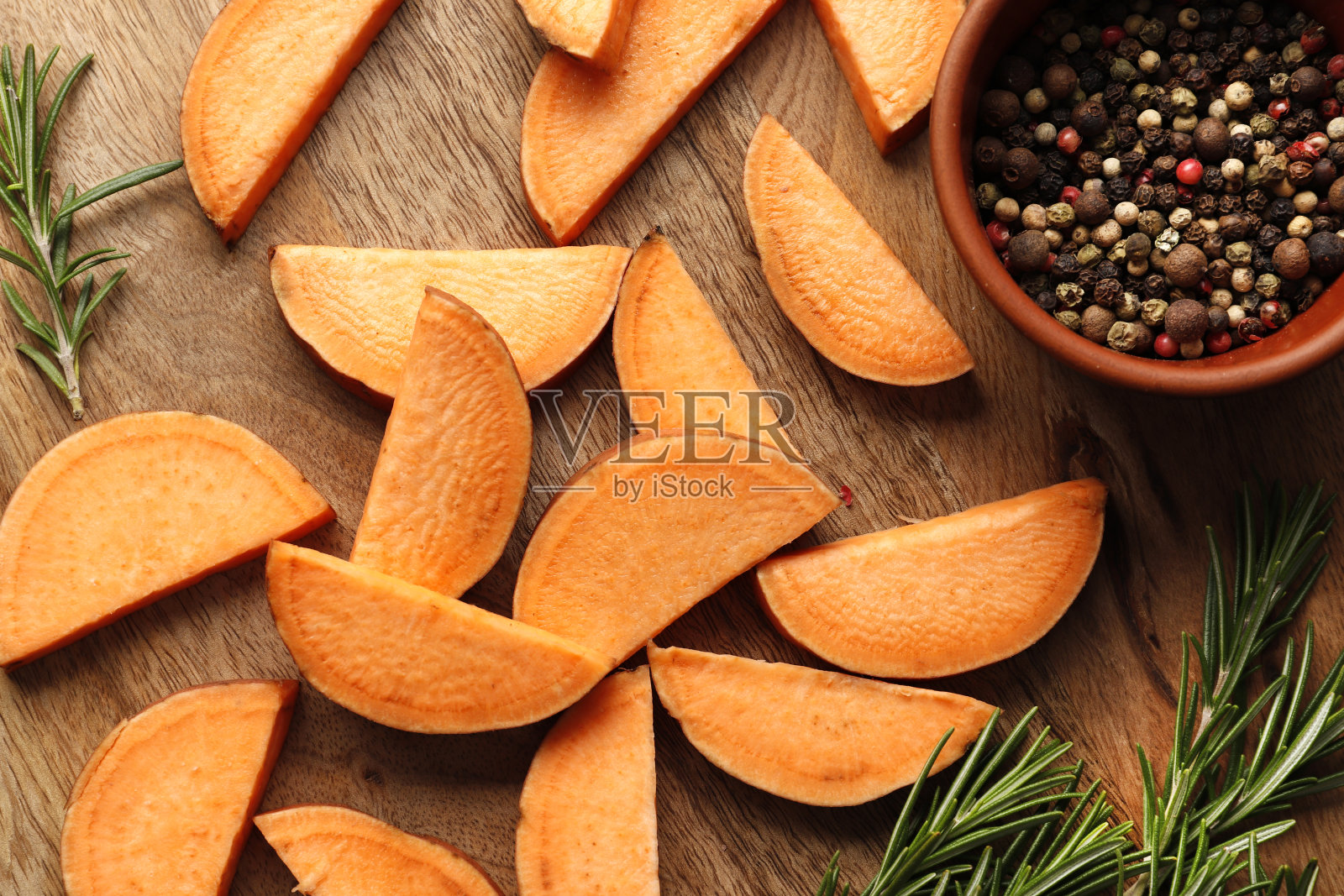 构图新鲜的红薯片,迷迭香香料,胡椒,盐,木制背景特写。照片摄影图片