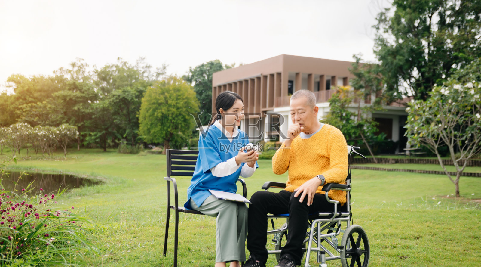 亚洲年轻护理护士支持老年男性户外行走。专科医生帮助和照顾老年人成熟。养老院医院花园照片摄影图片