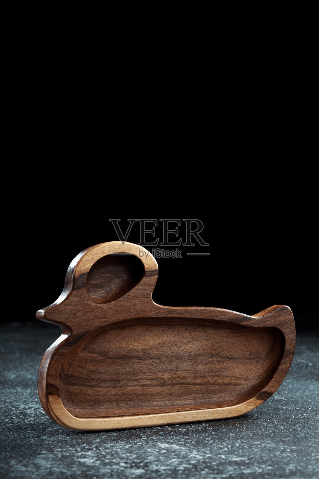 鸭子形状的儿童餐盘是用木头做成的,用来盛放小吃、水果、坚果、奶酪、肉类和原汁原味的主菜。照片摄影图片