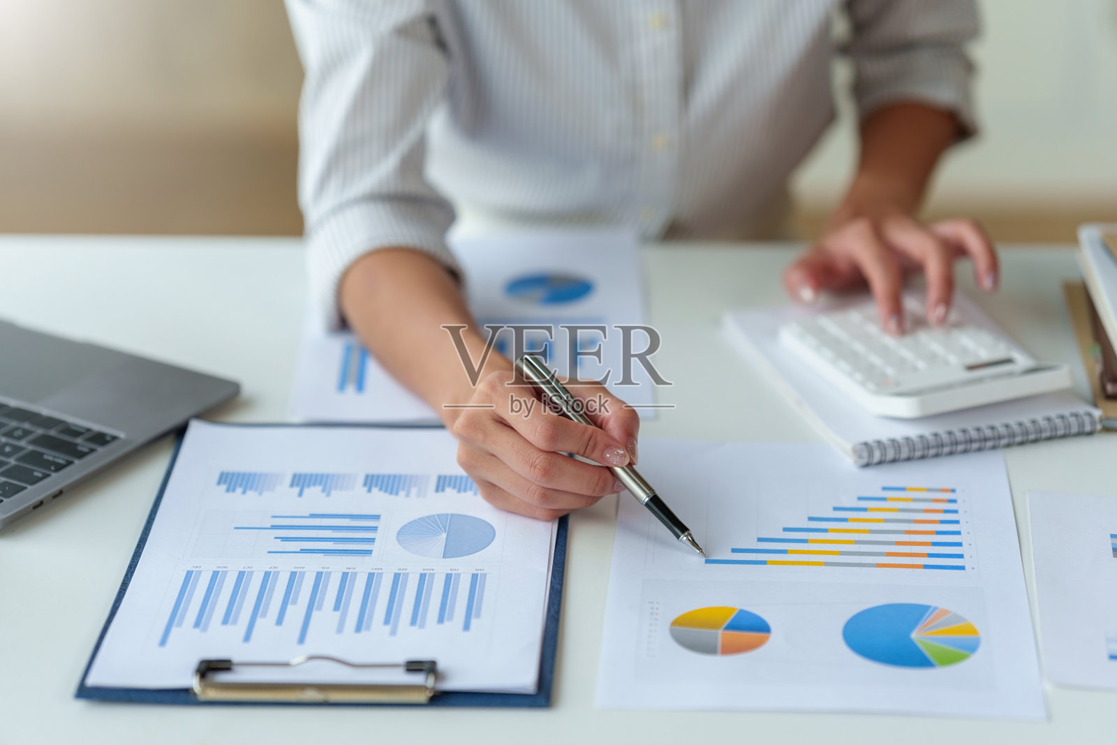 一位女商人的特写,分析每个季度比较的图表和图表,显示市场策略的变化。照片摄影图片