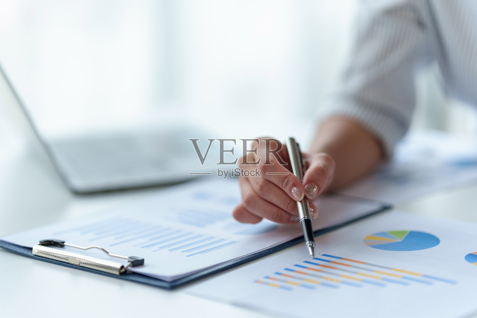 一位女商人的特写,分析每个季度比较的图表和图表,显示市场策略的变化。照片摄影图片