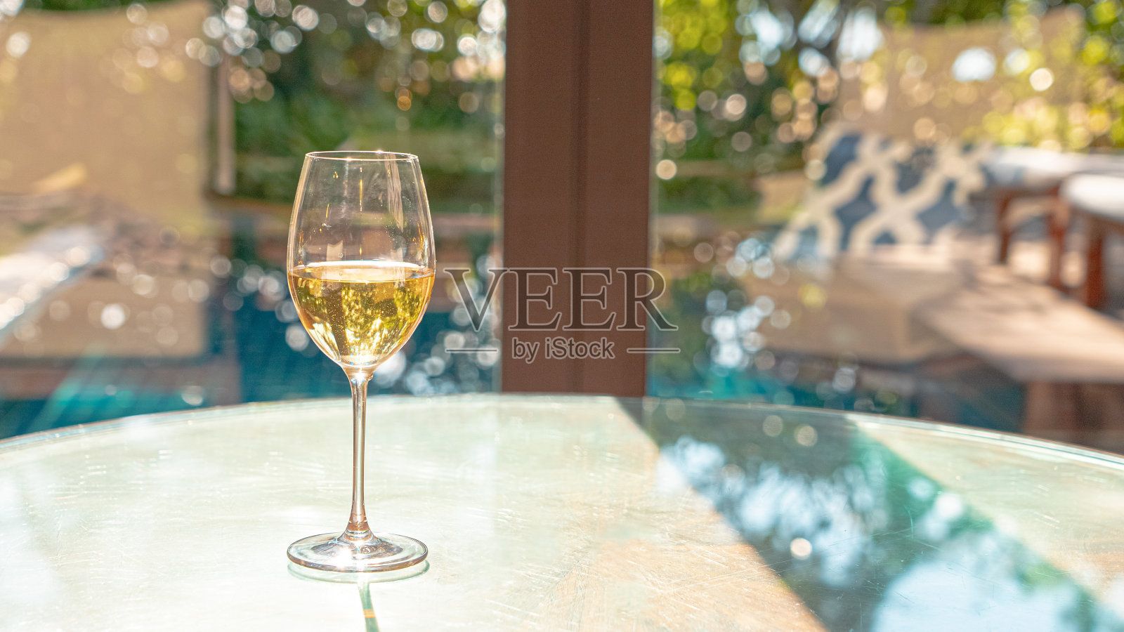 豪华木桌上的白葡萄酒杯在度假胜地舒适放松。照片摄影图片