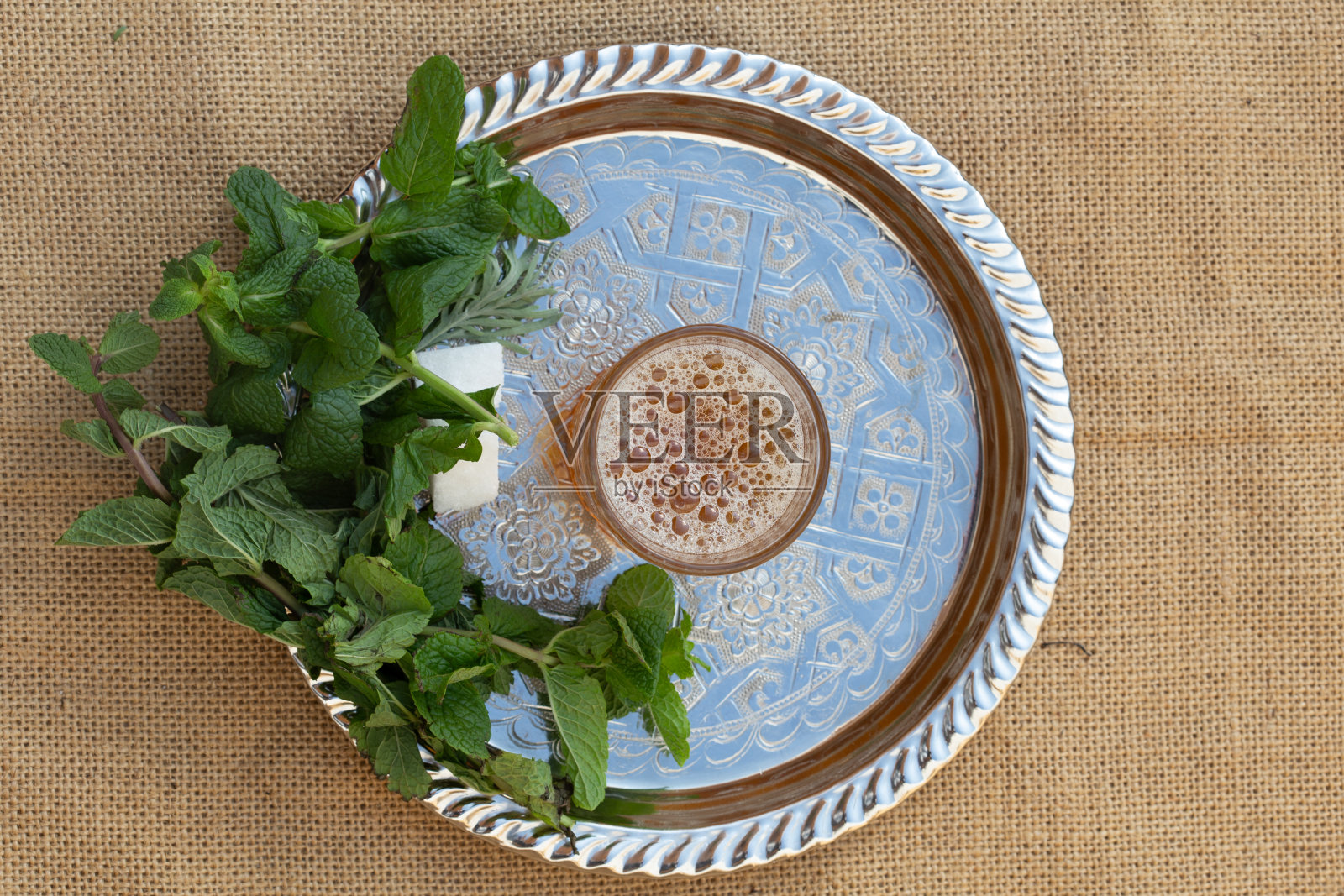 摩洛哥传统的茶壶和杯子放在银盘子上的特写照片摄影图片