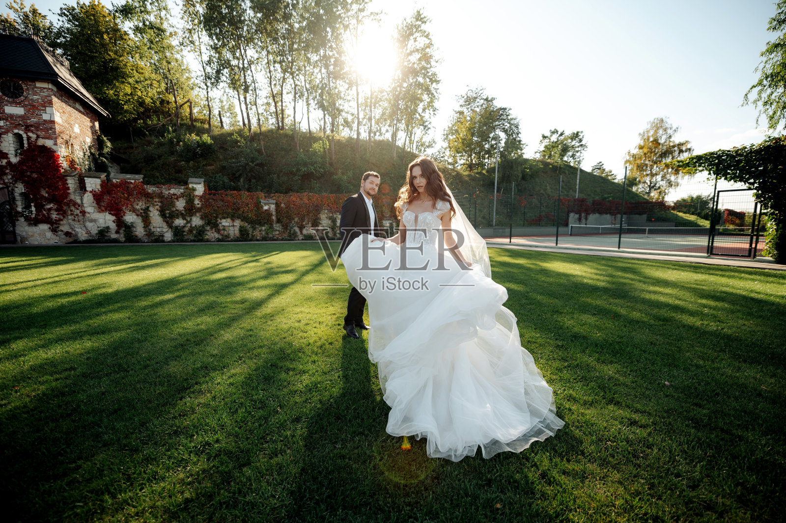 这对幸福的新娘和新郎在公园散步和摆姿势的全景照片照片摄影图片