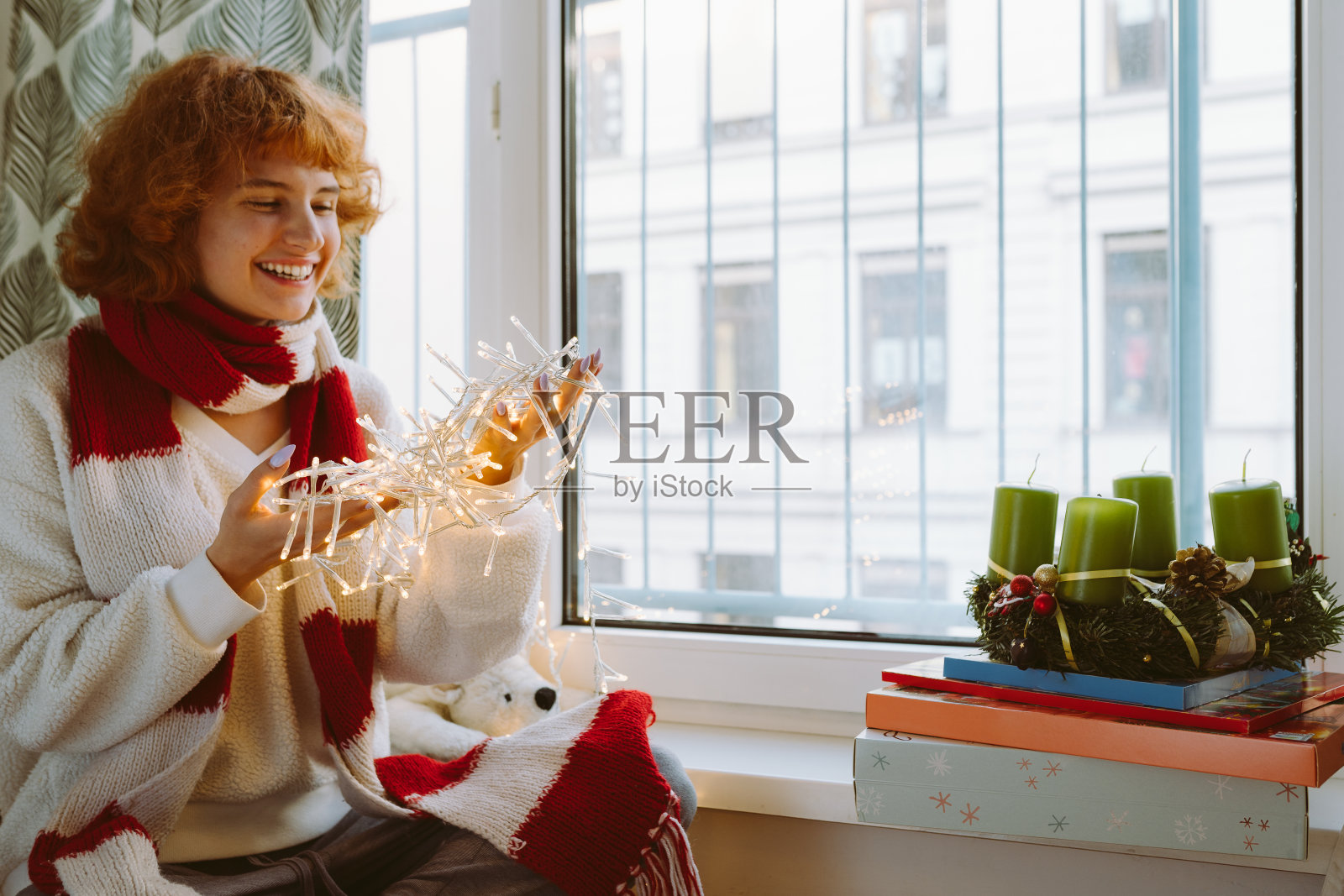 装饰着节日灯泡花环的红发少女照片摄影图片