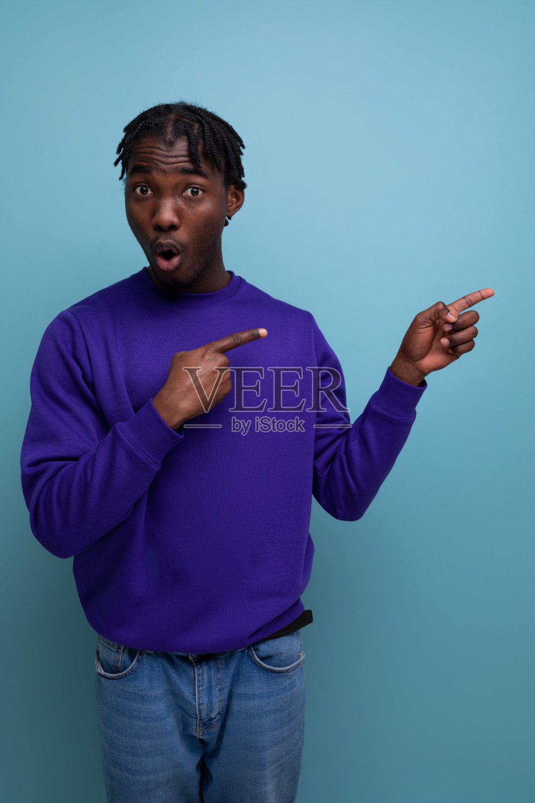 一个留着脏辫的非洲年轻人在墙上挂着广告照片摄影图片