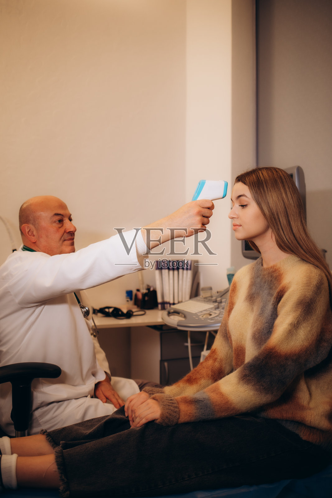 用体温计测量女性的体温,以确定是否感染了冠状病毒Covid-19。特写镜头。照片摄影图片