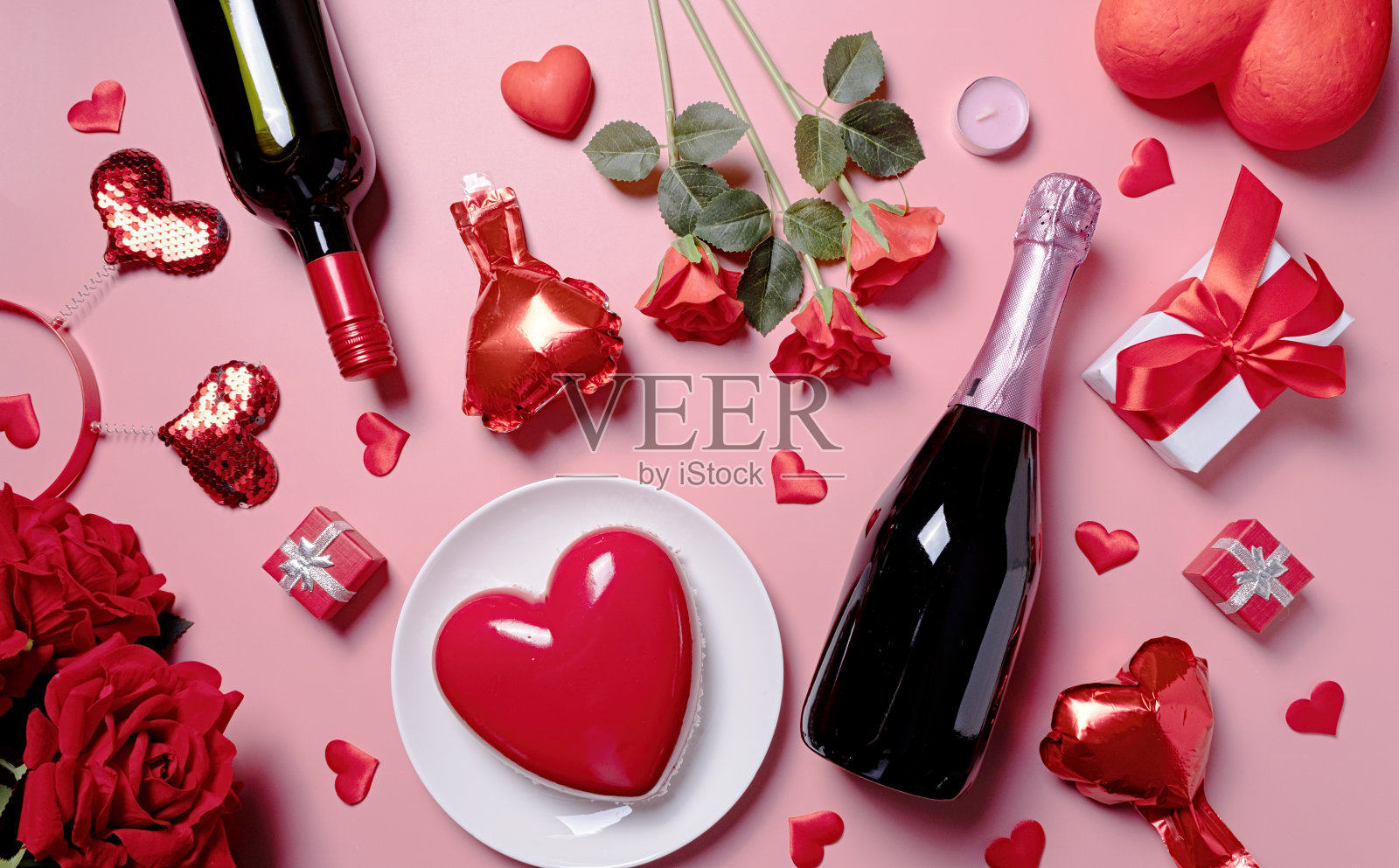粉红色背景上的情人节糖果、蛋糕和鲜花照片摄影图片