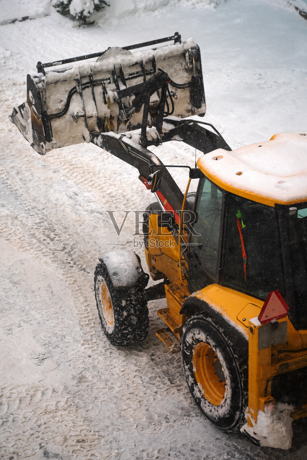 拖拉机在街上铲雪。照片摄影图片