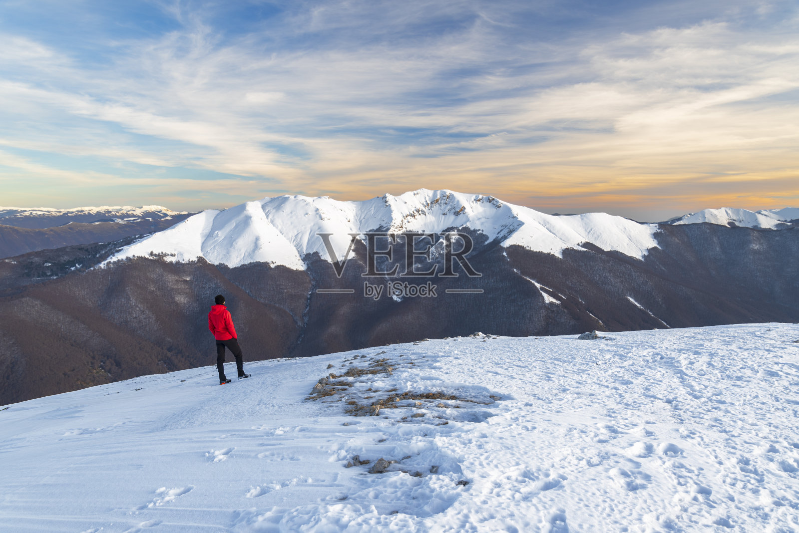 徒步旅行者站在雪峰前,亚平宁山脉,意大利照片摄影图片