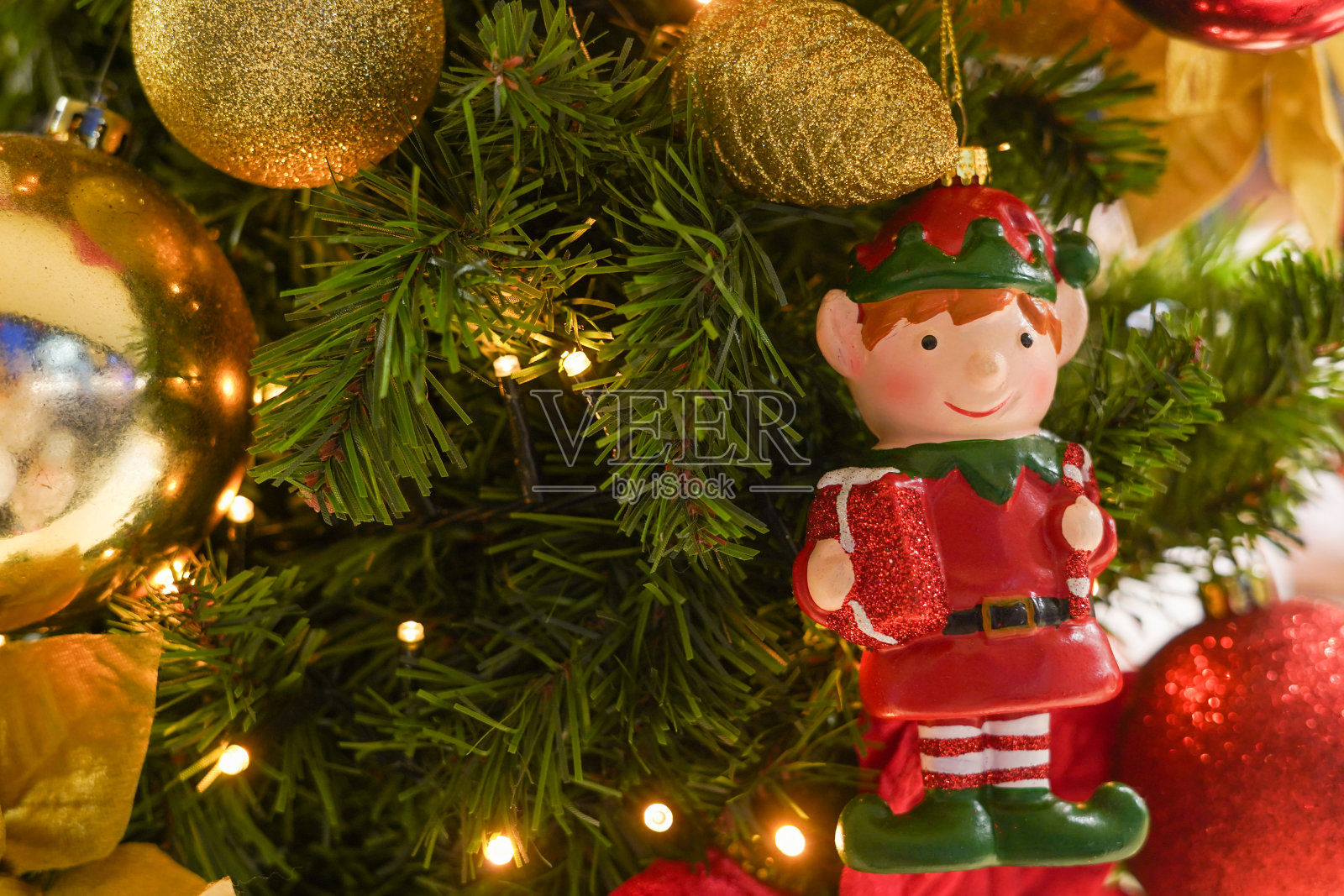 圣诞树上挂着金色和红色装饰的圣诞精灵照片摄影图片