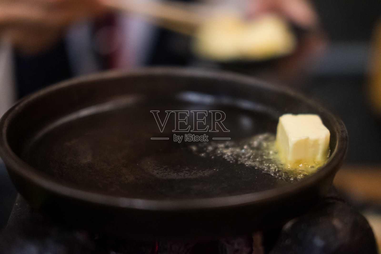 在餐馆里,黑锅是用油和黄油准备烹饪的。照片摄影图片