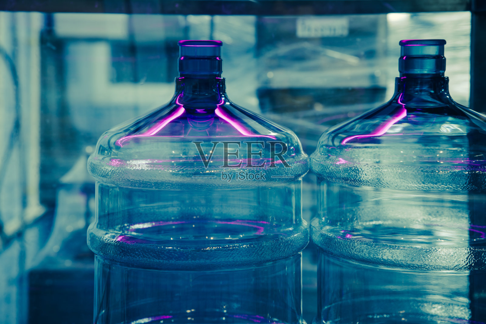 饮水厂在生产线上采用UV光消毒灭菌系统来清洗饮水瓶罐照片摄影图片