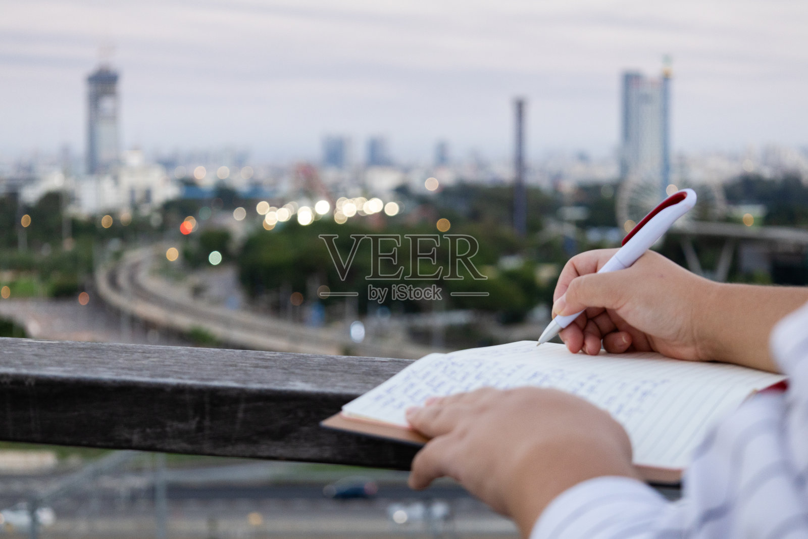 女人用钢笔在笔记本上写字照片摄影图片