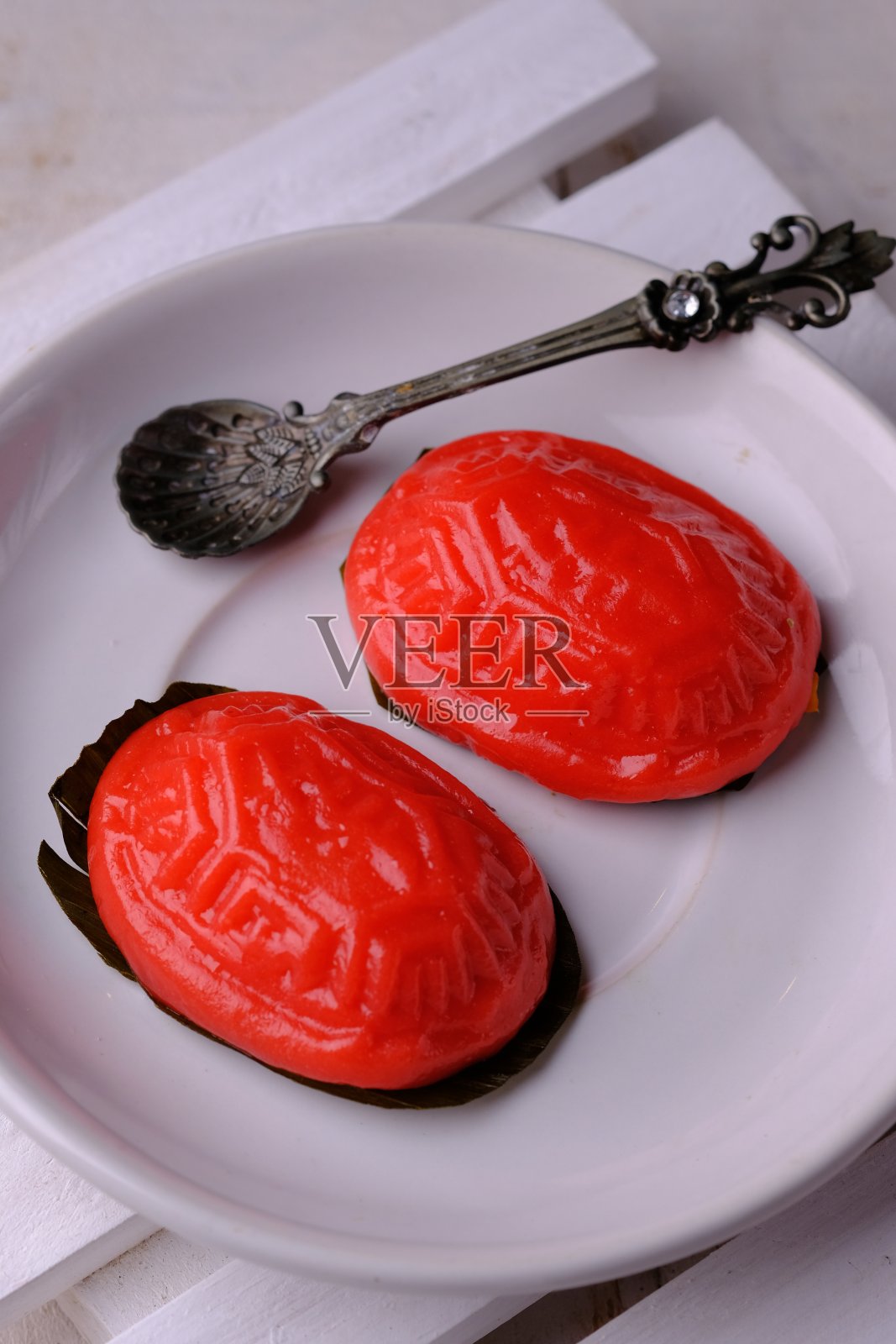 红龟糕,也被称为红龟糕,是一种小圆形或椭圆形的中式糕点,软糯的糯米粉表皮包裹着甜的馅料。带来的骨。照片摄影图片