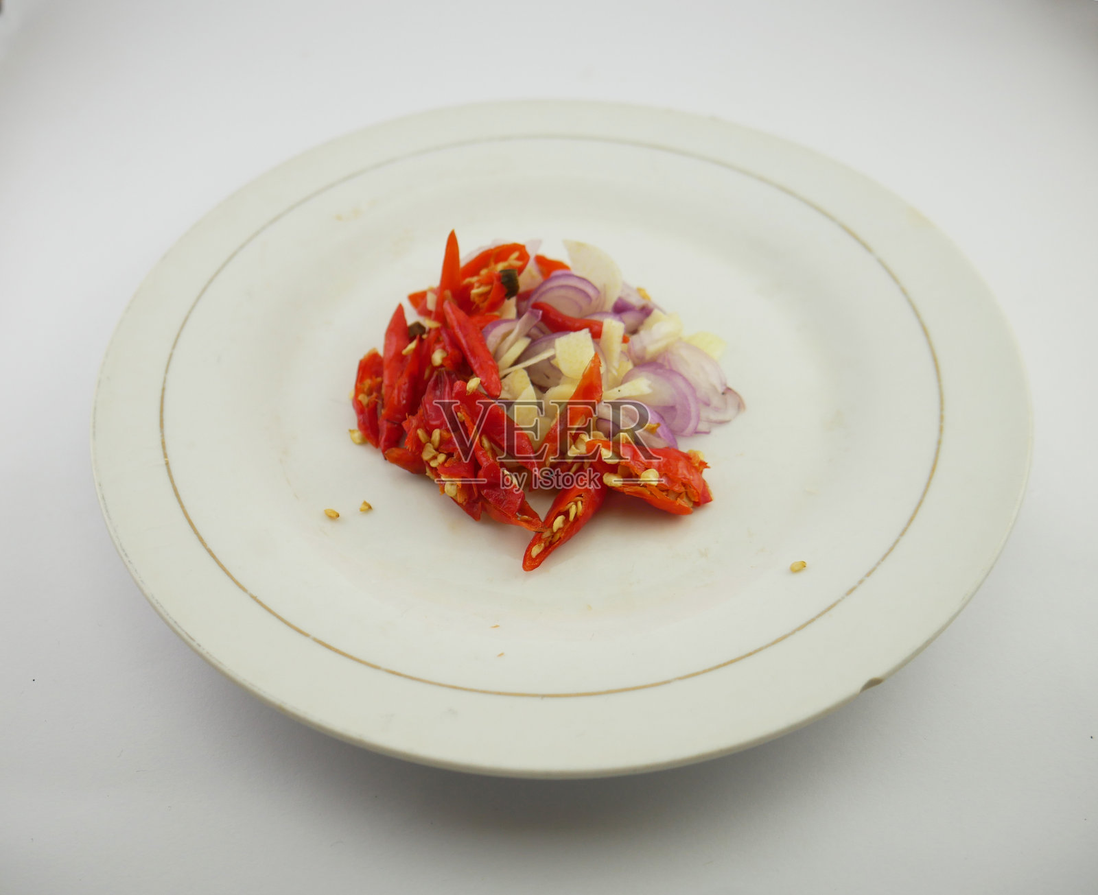 切成薄片的洋葱、辣椒和大蒜放在盘子里照片摄影图片