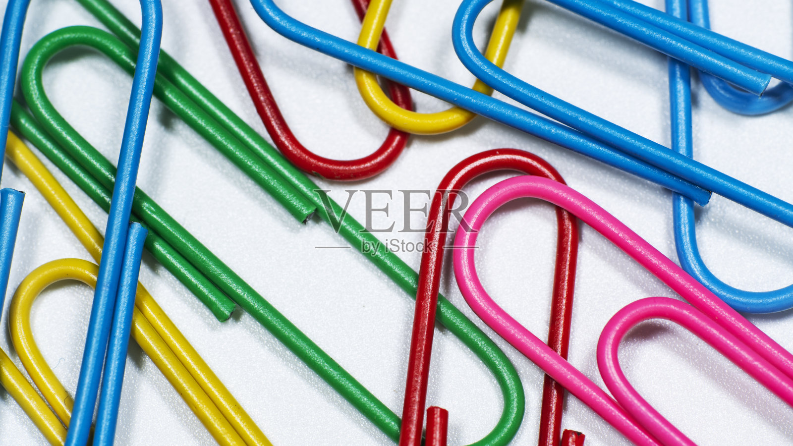 各色彩色回形针的特写,孤立在白色背景上照片摄影图片