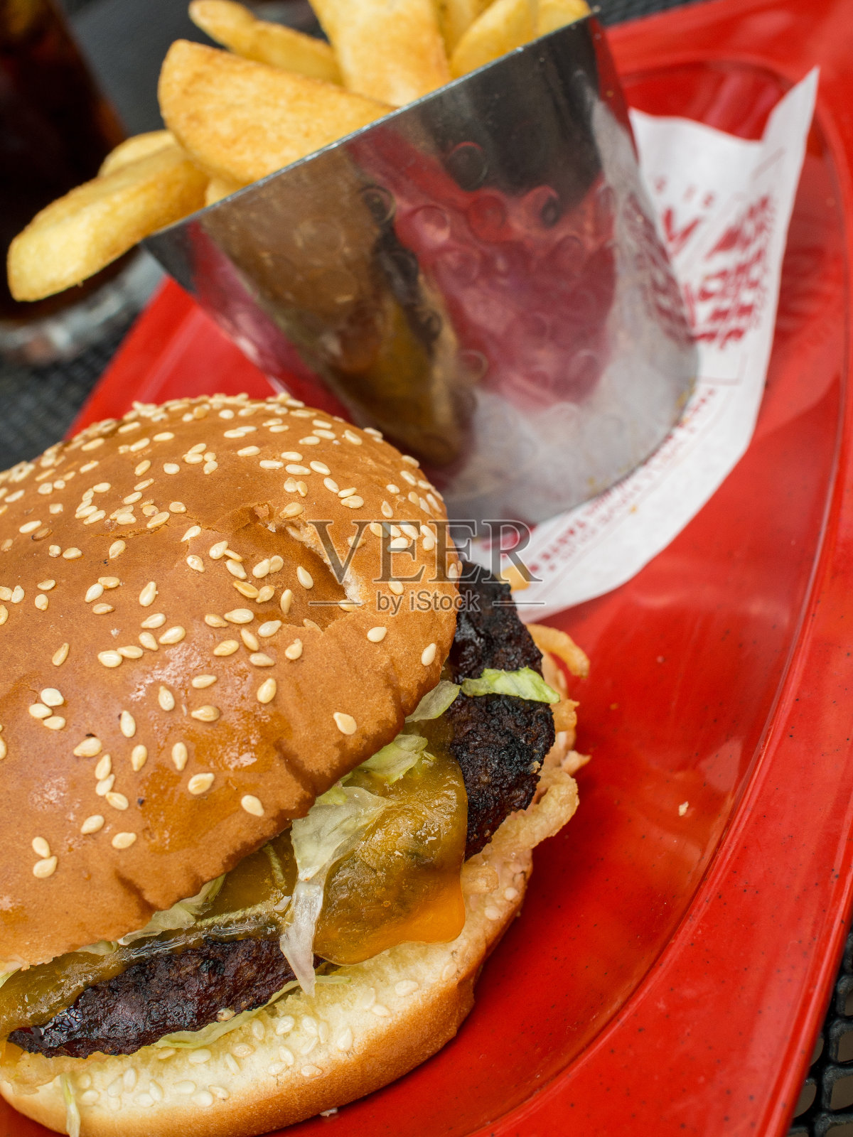 美味的汉堡包着薯条,全是红色的衬垫。照片摄影图片