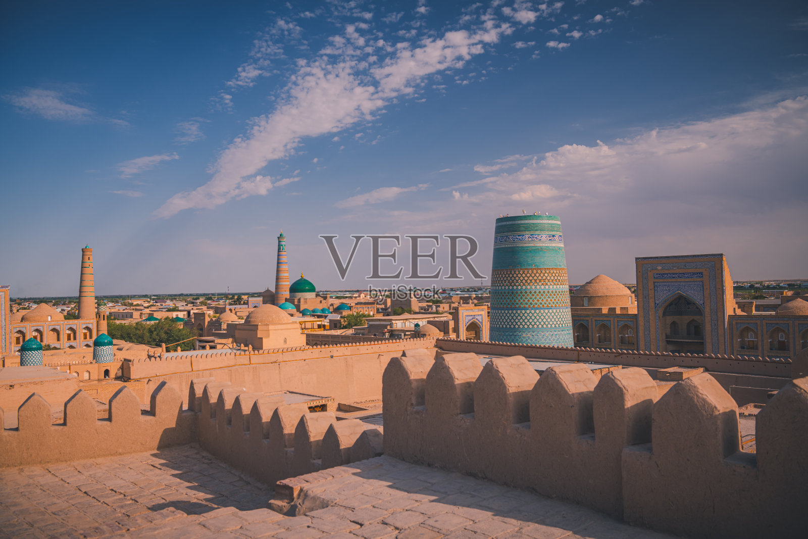 乌兹别克斯坦,日出时的希瓦老城,背景是伊斯兰教的胡贾尖塔照片摄影图片