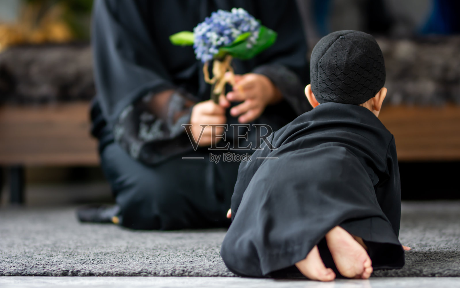 可爱天真的穆斯林小男孩穿着传统服装,坐在家里客厅的地板上,独自玩着拷贝空间。教育,孩子,宗教观念。照片摄影图片