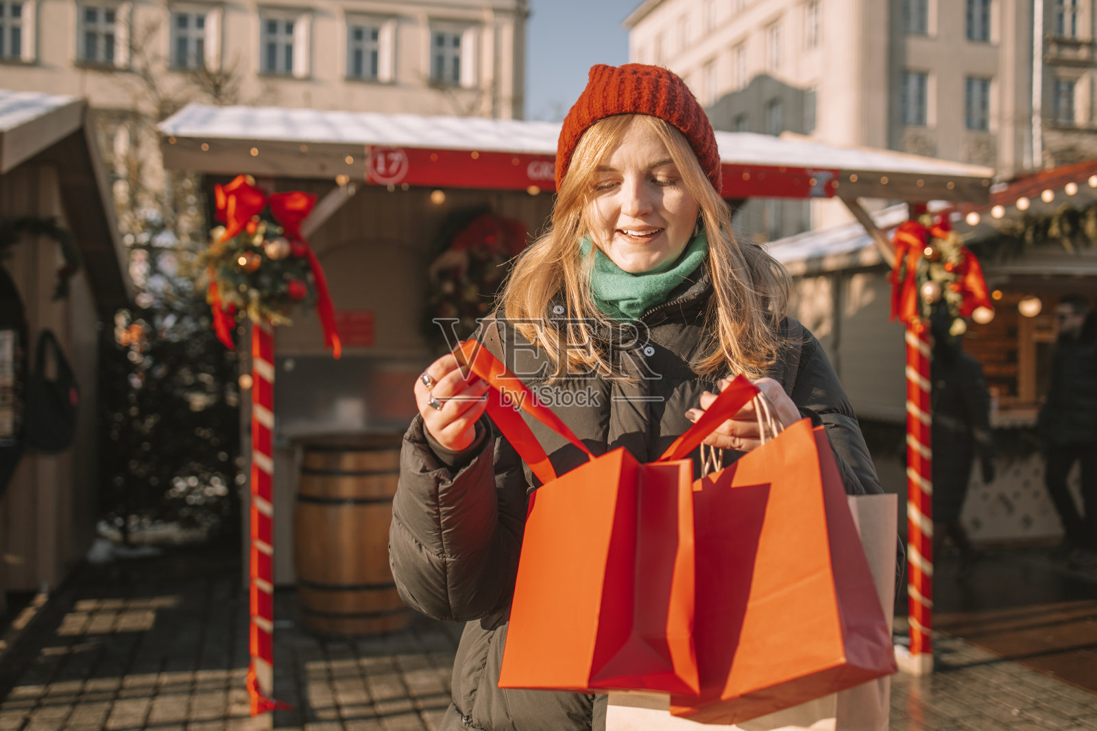 快乐的年轻美丽的女人在市场挑选圣诞礼物和圣诞树照片摄影图片