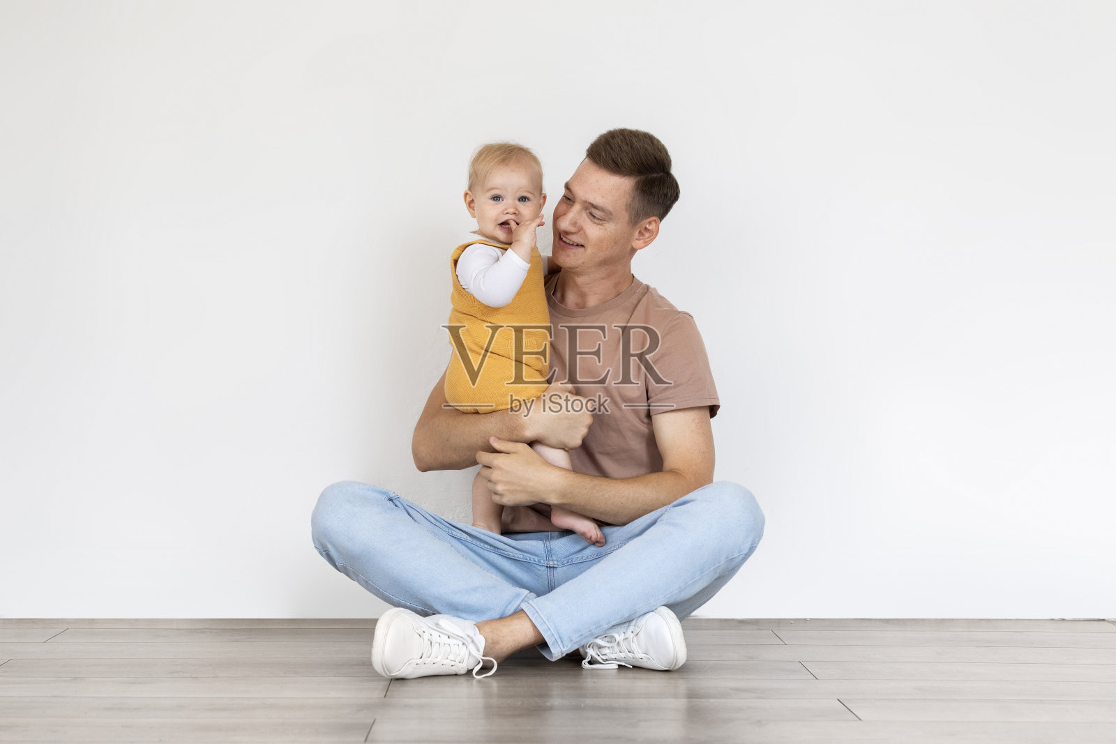 快乐的年轻父亲在家里抱着他可爱的儿子照片摄影图片