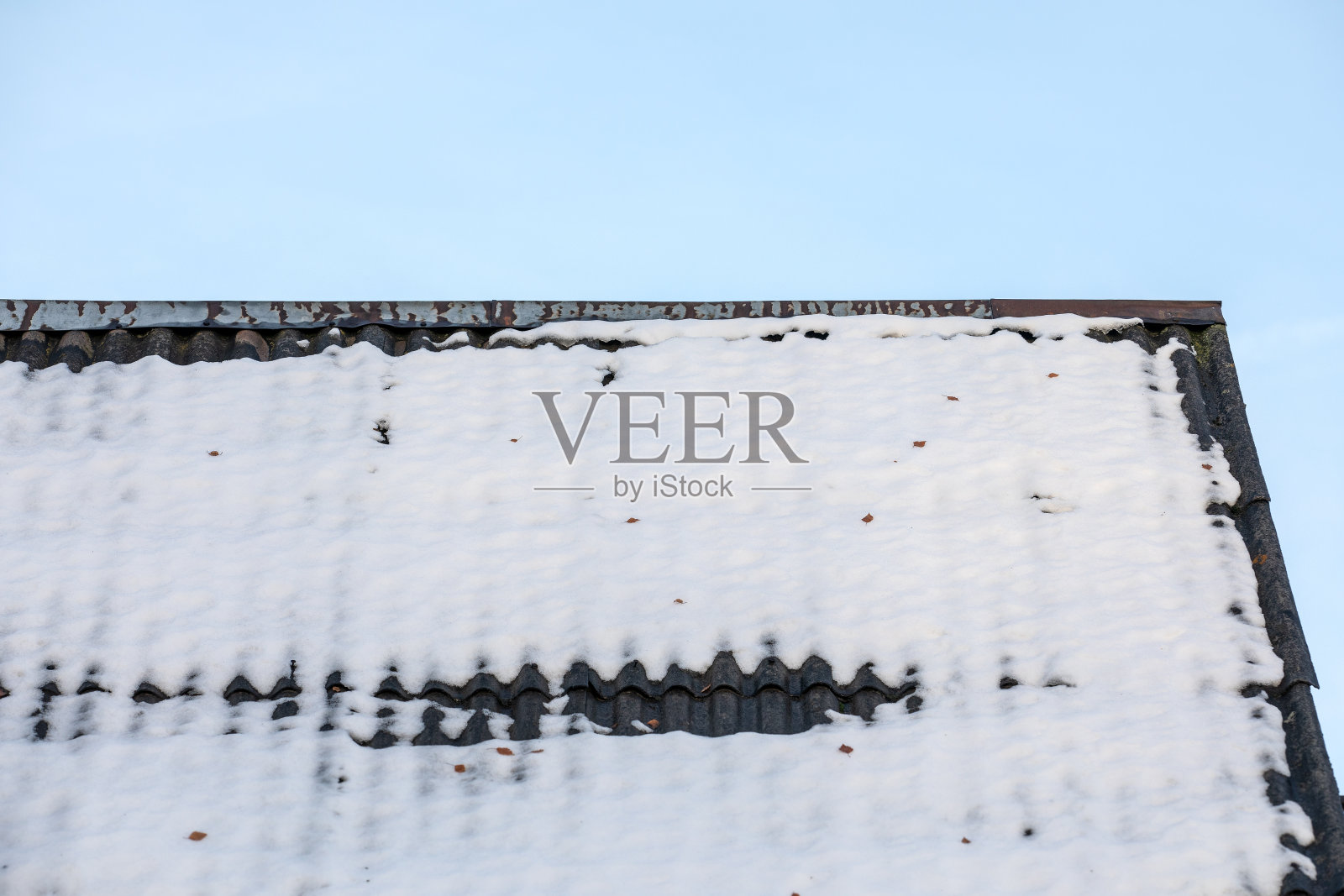 融雪的石板屋顶上,碧蓝的天空照片摄影图片