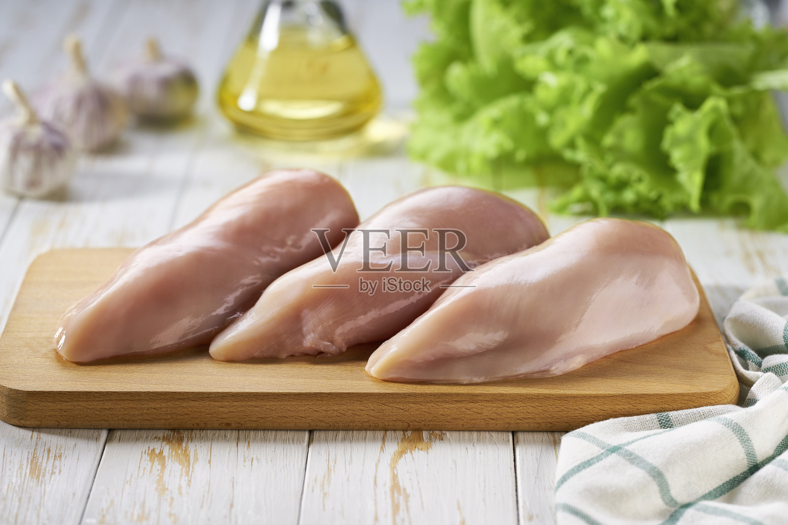 木制砧板用鸡胸片和香料和香草,选择性重点。照片摄影图片