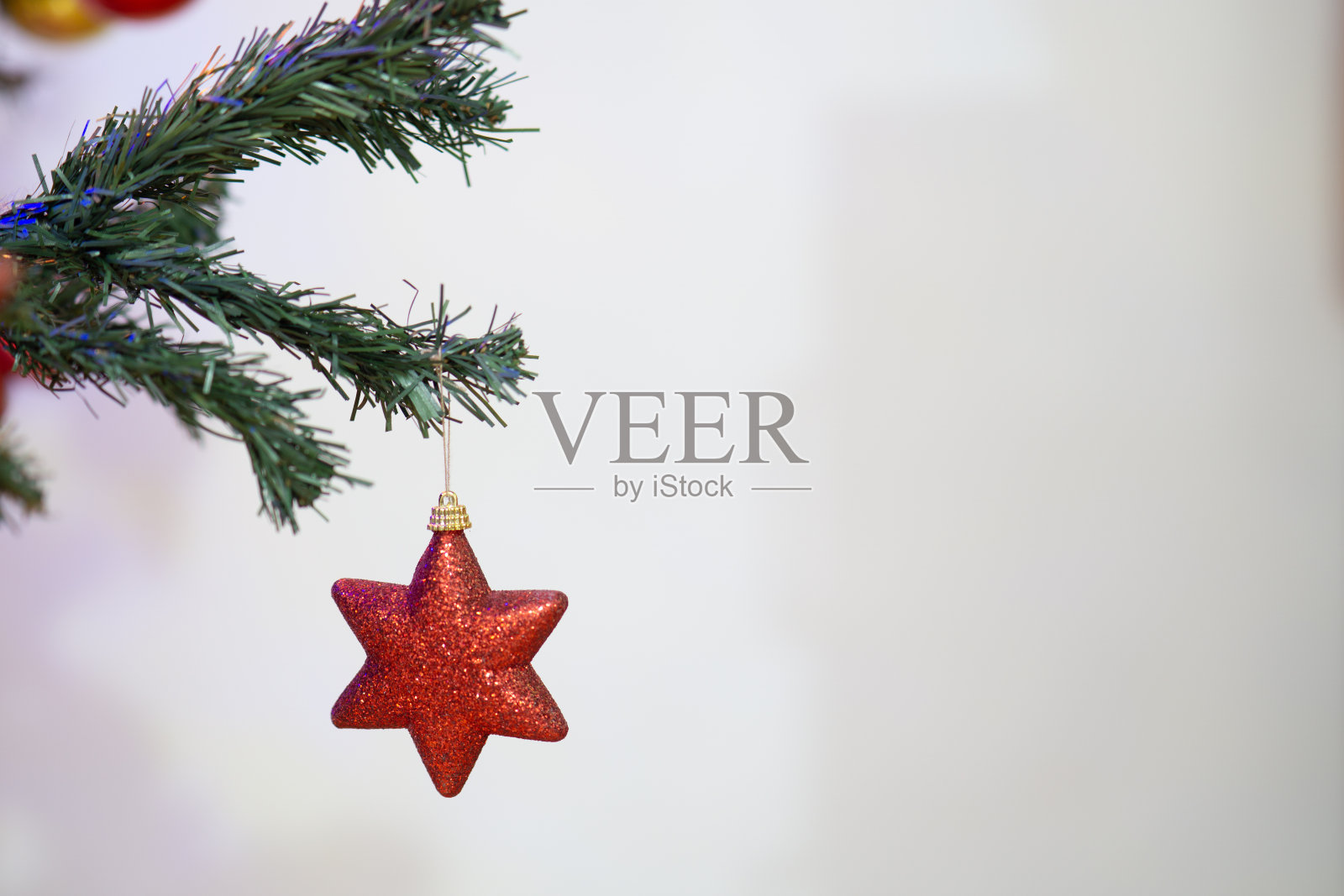 圣诞红星装饰挂在圣诞树上近距离孤立的白色背景复制空间照片摄影图片