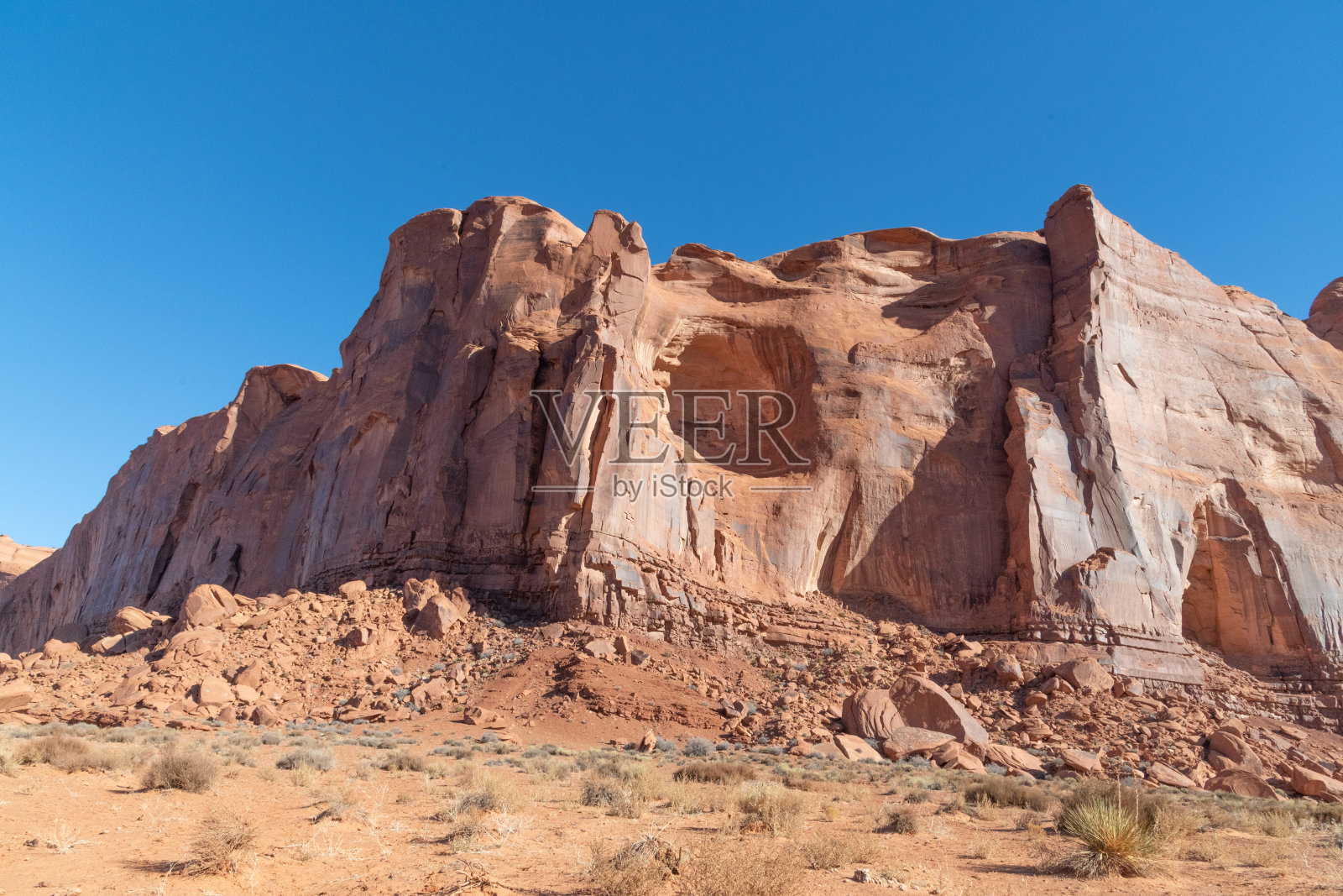 在美国西部的亚利桑那州和犹他州的纪念碑谷附近,高大的砂岩尖塔和丰富的暗红色崎岖山脉的台地照片摄影图片