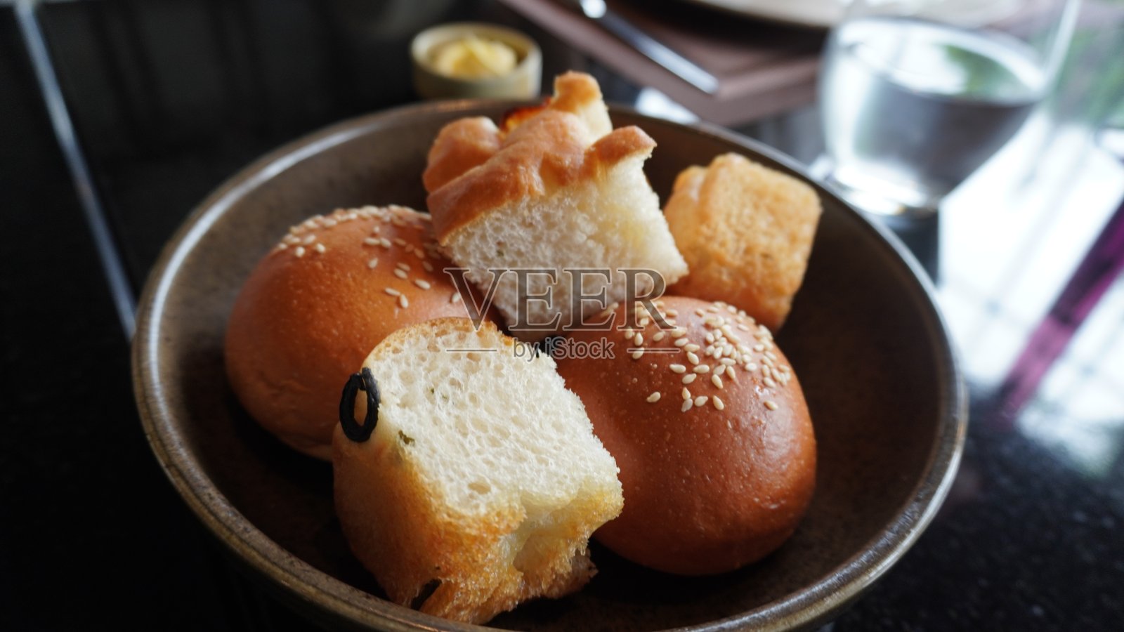 新鲜出炉的面包作为开胃菜,装在陶瓷碗里照片摄影图片