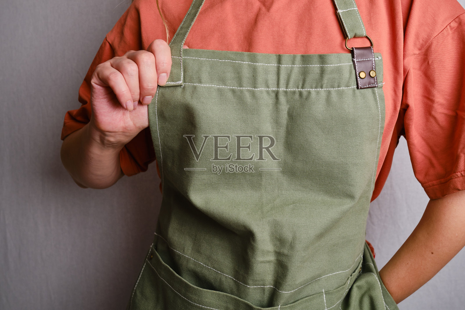 穿着厨房围裙的女人。厨师从事烹饪工作。穿着制服和防护服。食品服务方面的工作。专业烹饪。绿色面料围裙,休闲服。英俊的面包师摆姿势照片摄影图片