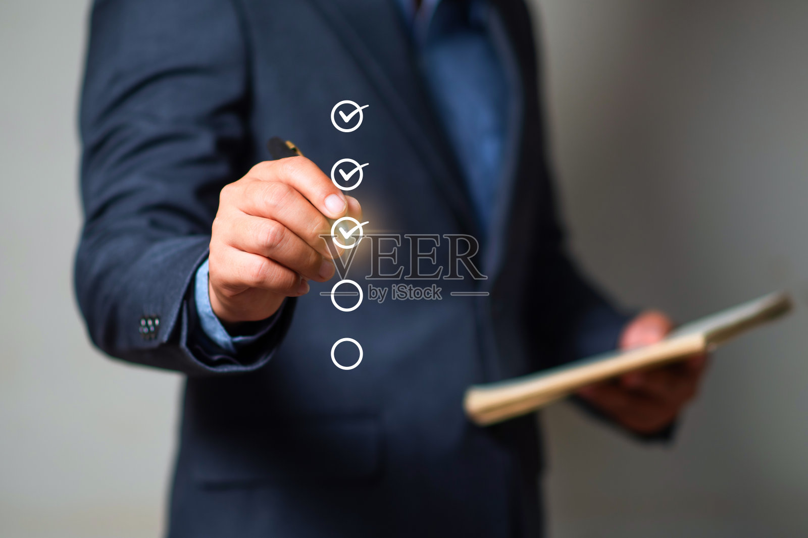 商人用笔在复选框中打正确的标记以批准文件和项目概念。照片摄影图片