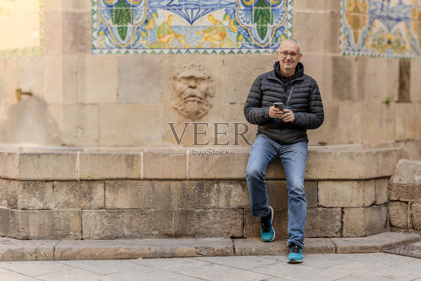 一个成熟的成年人坐在喷泉上,正面照片摄影图片