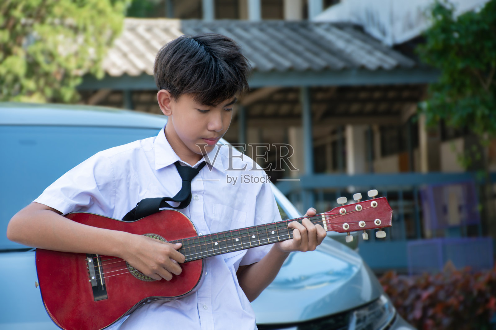 一个亚洲男生会弹尤克里里照片摄影图片