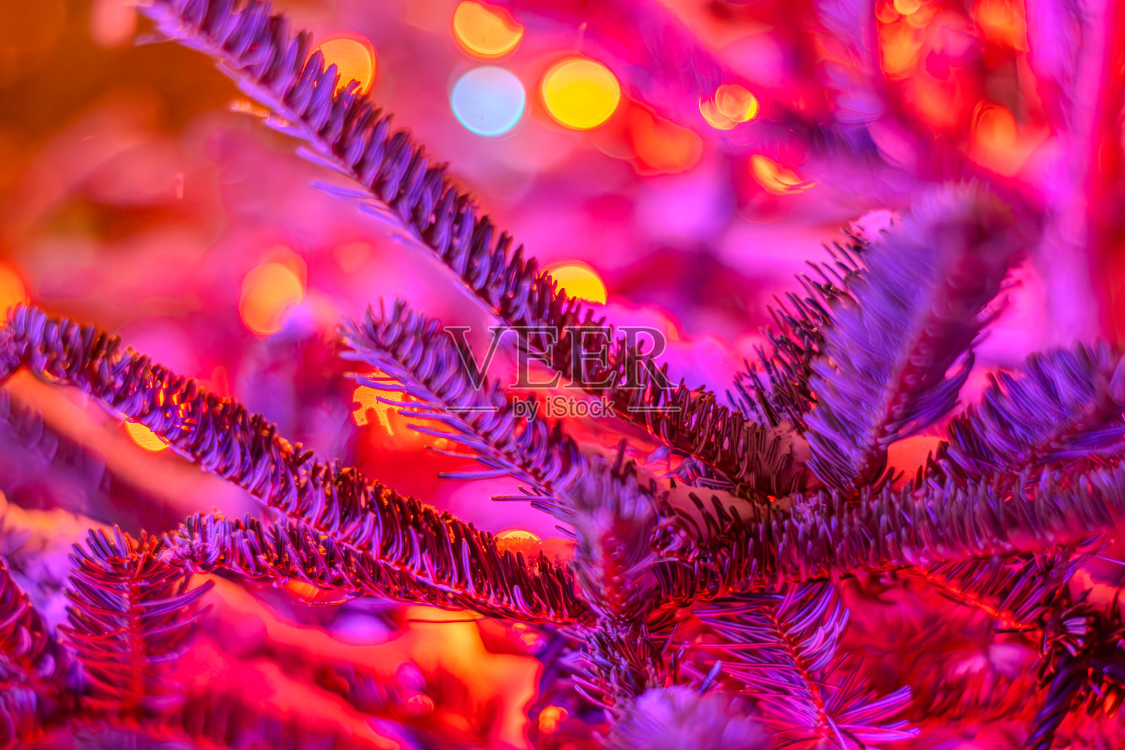 圣诞树上的新年花环。模糊背景的圣诞树装饰和灯。以发光的黄色圣诞灯为背景的冷杉树枝照片摄影图片