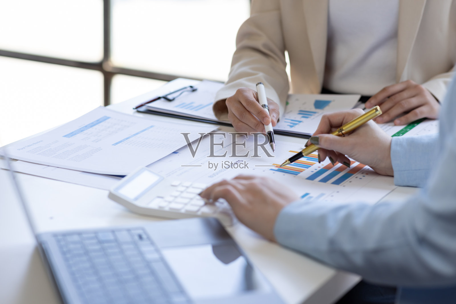 亚洲业务团队使用计算器和笔记本电脑在木桌上做数学、财务、税务、会计、统计和分析研究概念照片摄影图片