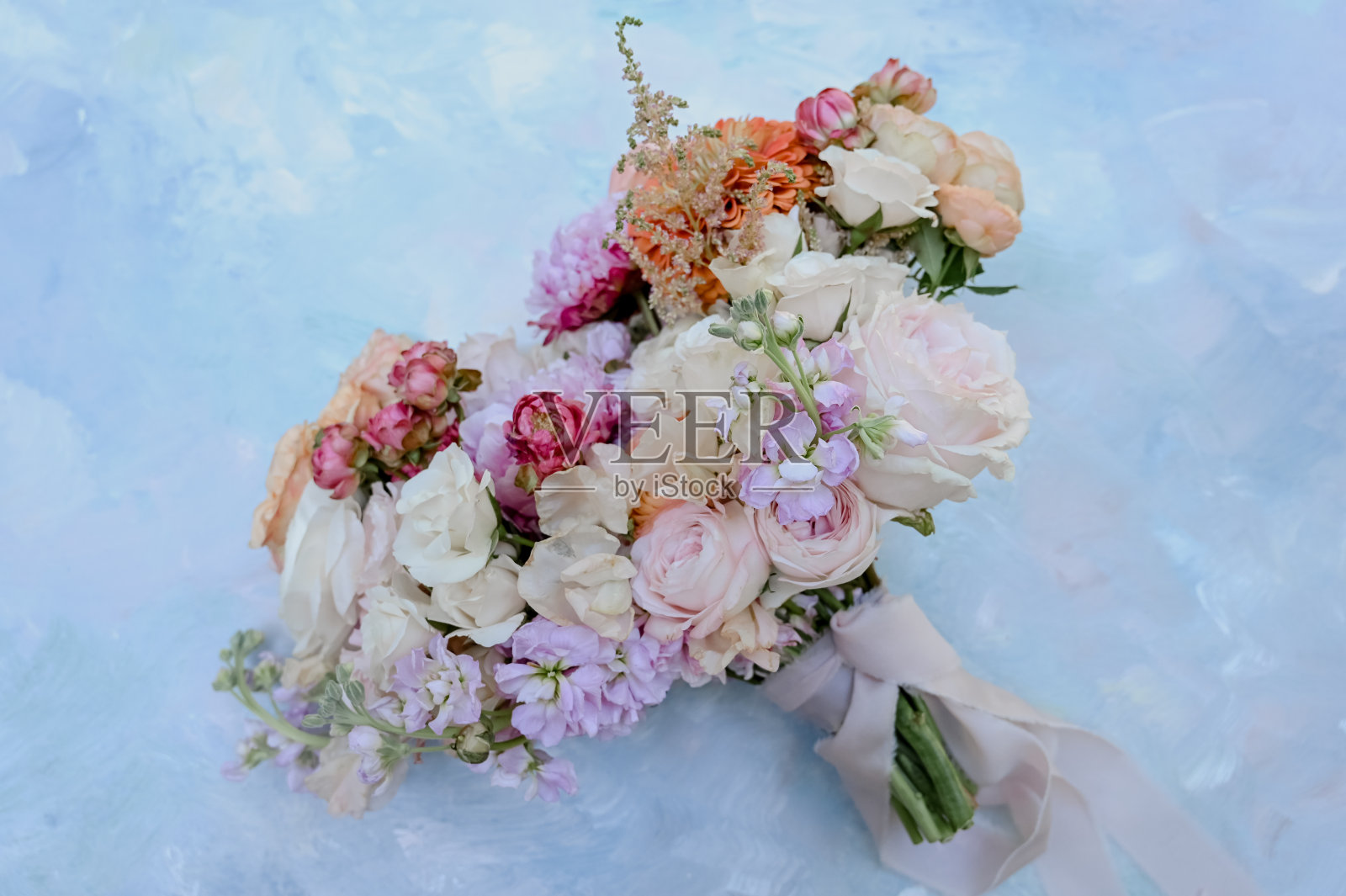 色彩缤纷的春天婚礼花束在蓝色的表面照片摄影图片