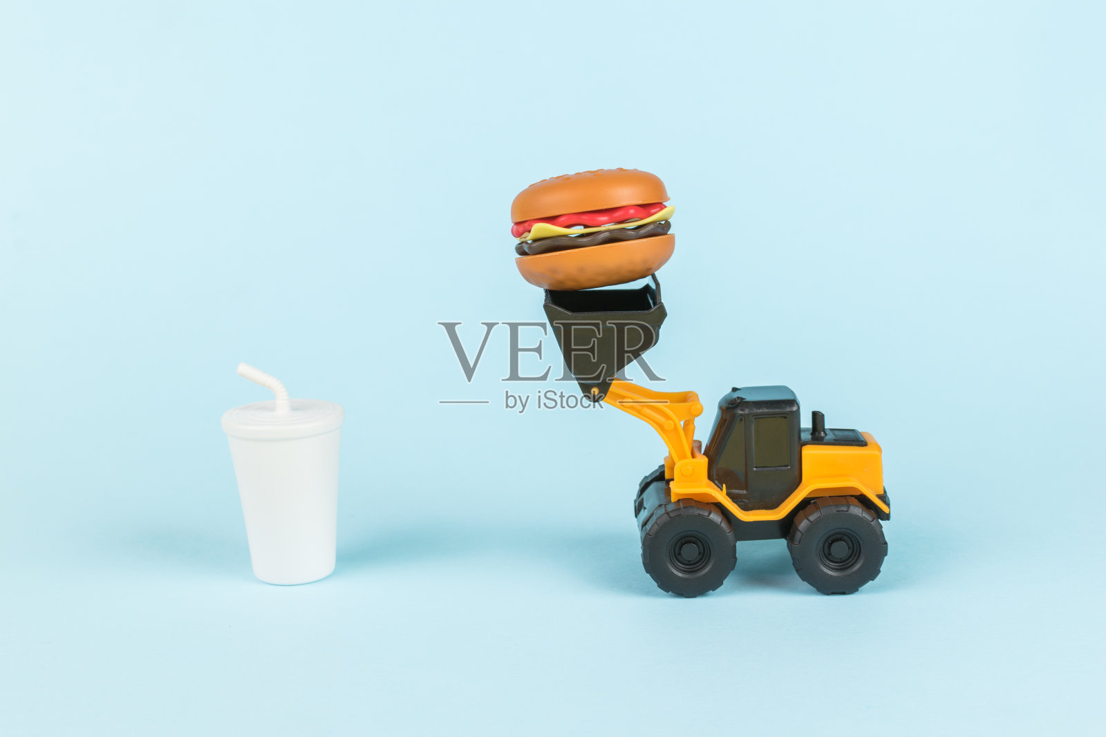 一杯饮料和一台送汉堡的推土机。照片摄影图片