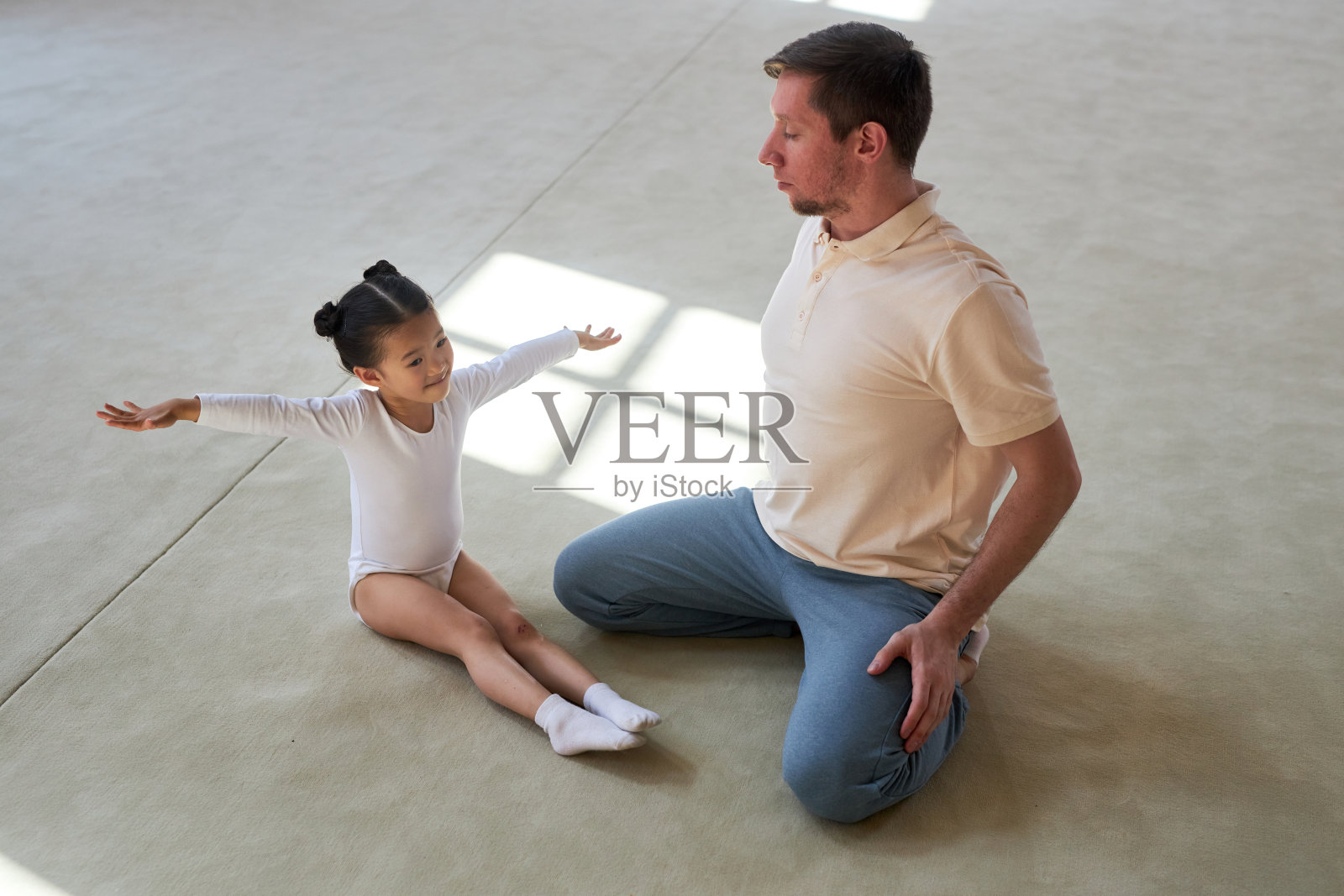 微笑的小体操运动员和教练一起锻炼照片摄影图片