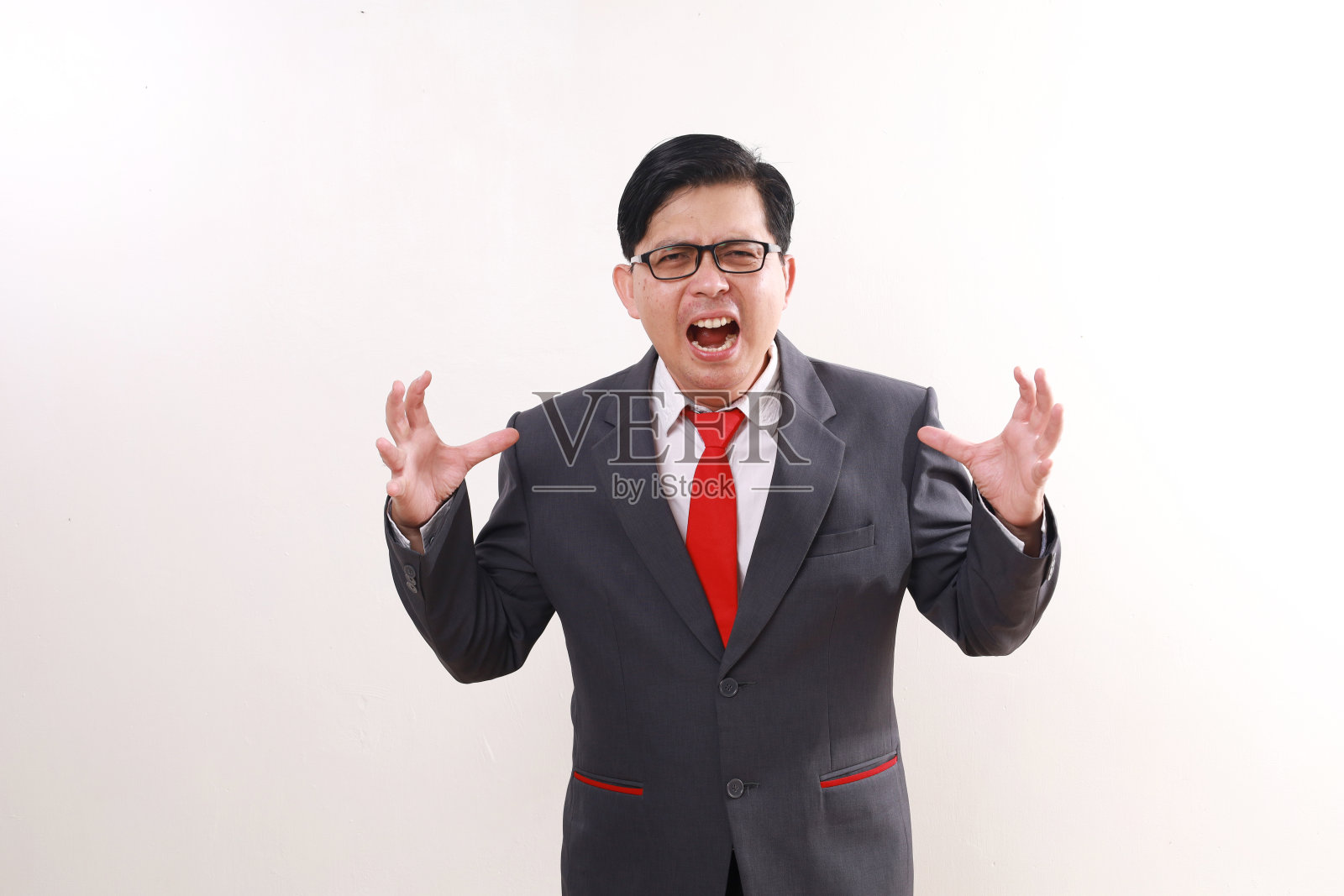 愤怒的亚洲商人一边站着一边尖叫。隔离在白色背景上照片摄影图片
