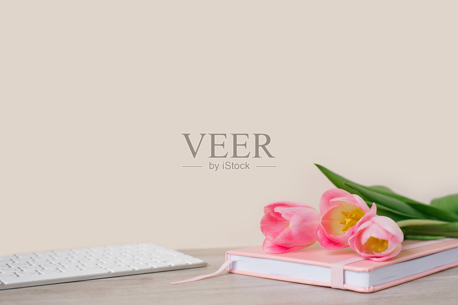 工作空间与键盘,粉红色的日记和粉红色的郁金香在木制背景。文本空间照片摄影图片