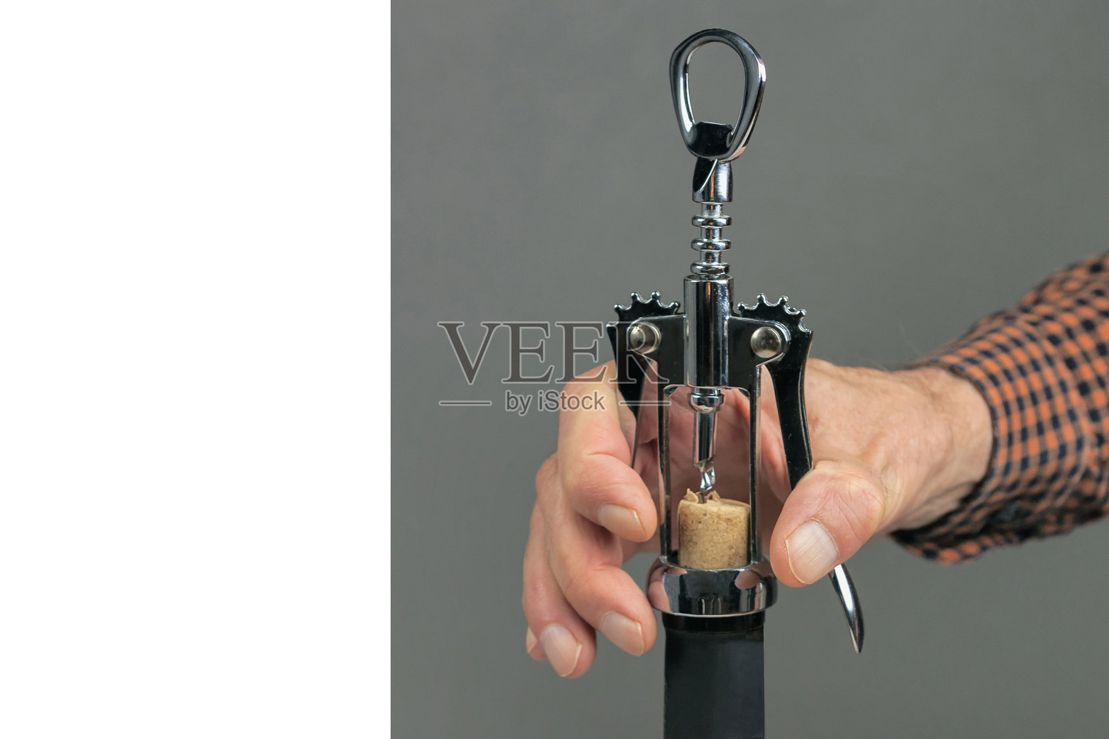 男人的手把瓶塞从酒瓶里拔了出来照片摄影图片