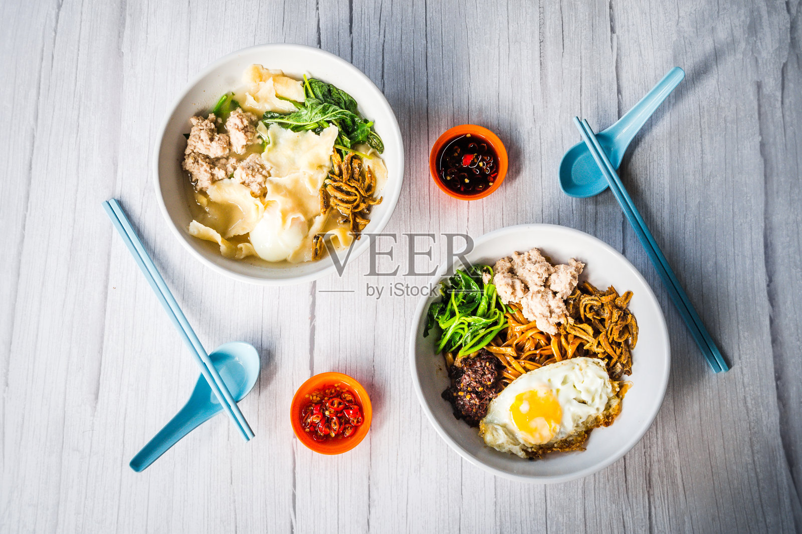 干拌面条和中国面食粉片在肉末、鸡蛋、炸凤尾鱼和菠菜的汤汁中煮熟照片摄影图片