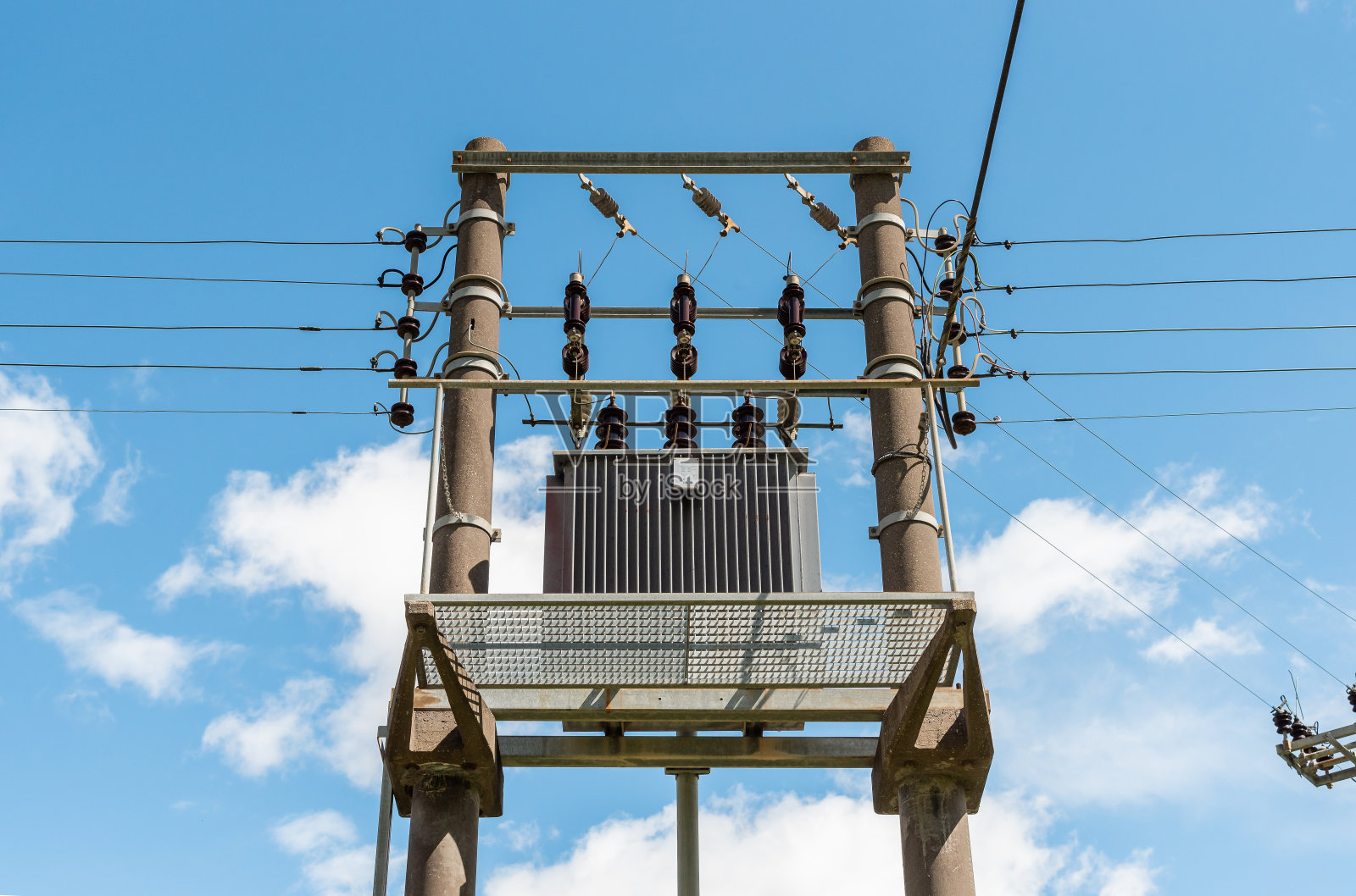 蓝天下的变压器和高压电线。照片摄影图片