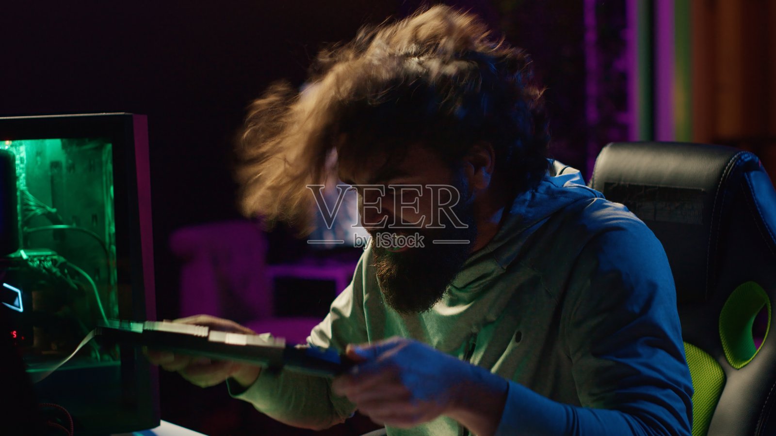 在输掉在线竞技多人游戏后,愤怒的玩家将键盘砸向头部照片摄影图片