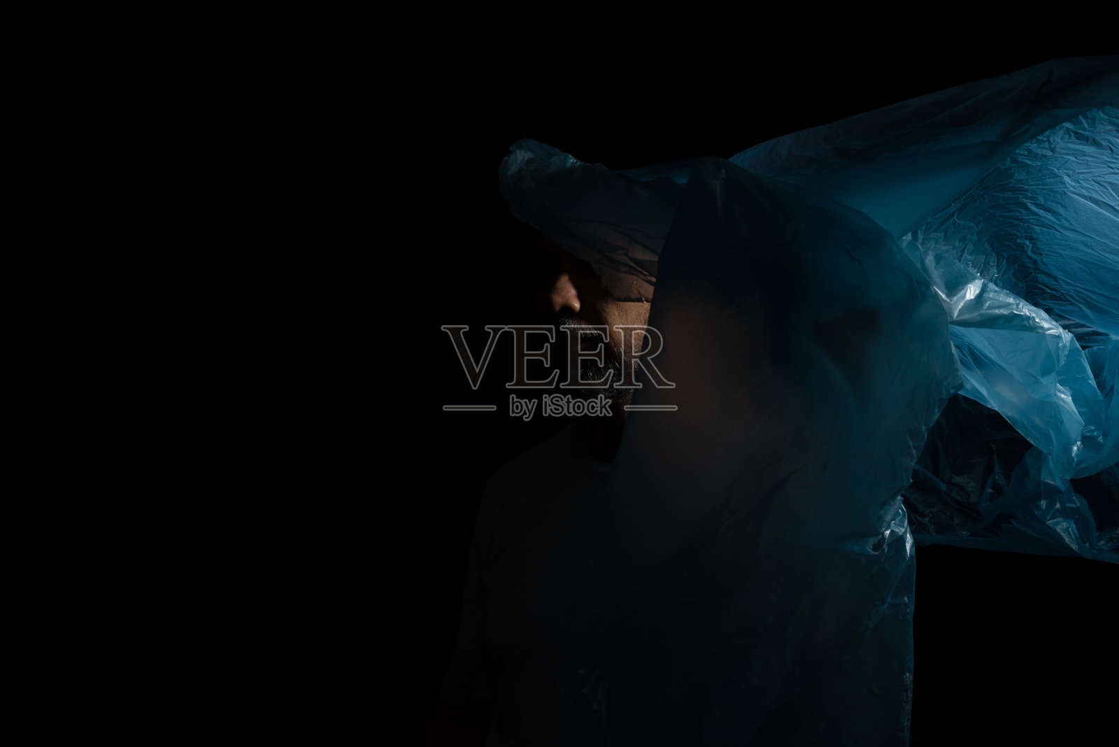 一个拿着蓝色塑料袋的男人照片摄影图片