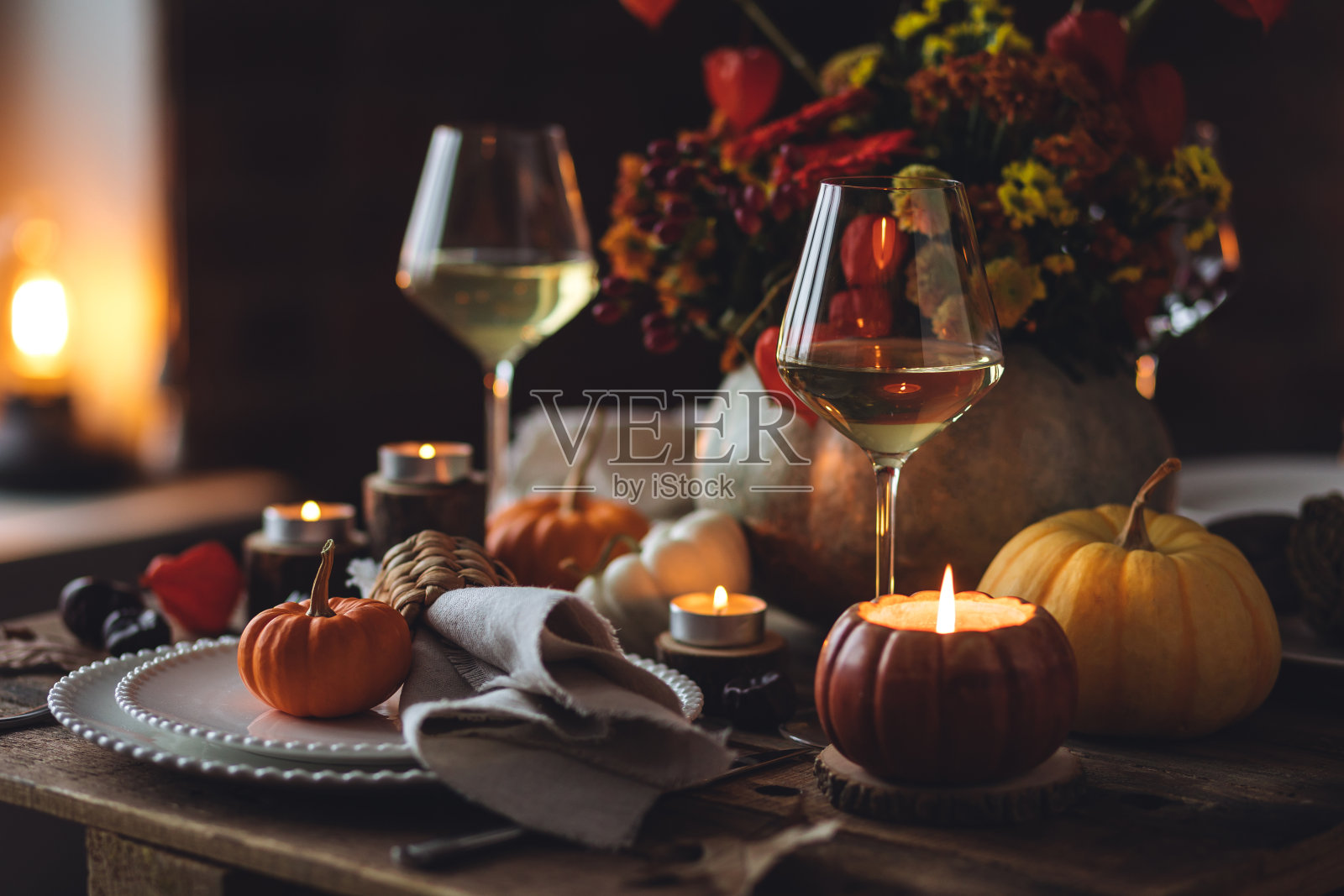 秋季餐桌装饰用南瓜、酒。家庭温馨的感恩节晚餐布置在室内,婚礼装饰优雅。田园风格,简单手工设置,秋天的心情,灵感。照片摄影图片
