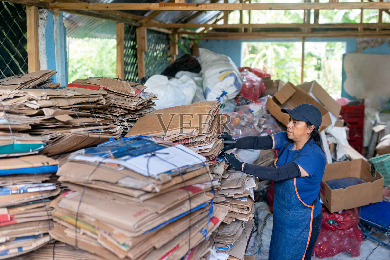 西班牙裔妇女在仓库管理回收纸板库存照片摄影图片